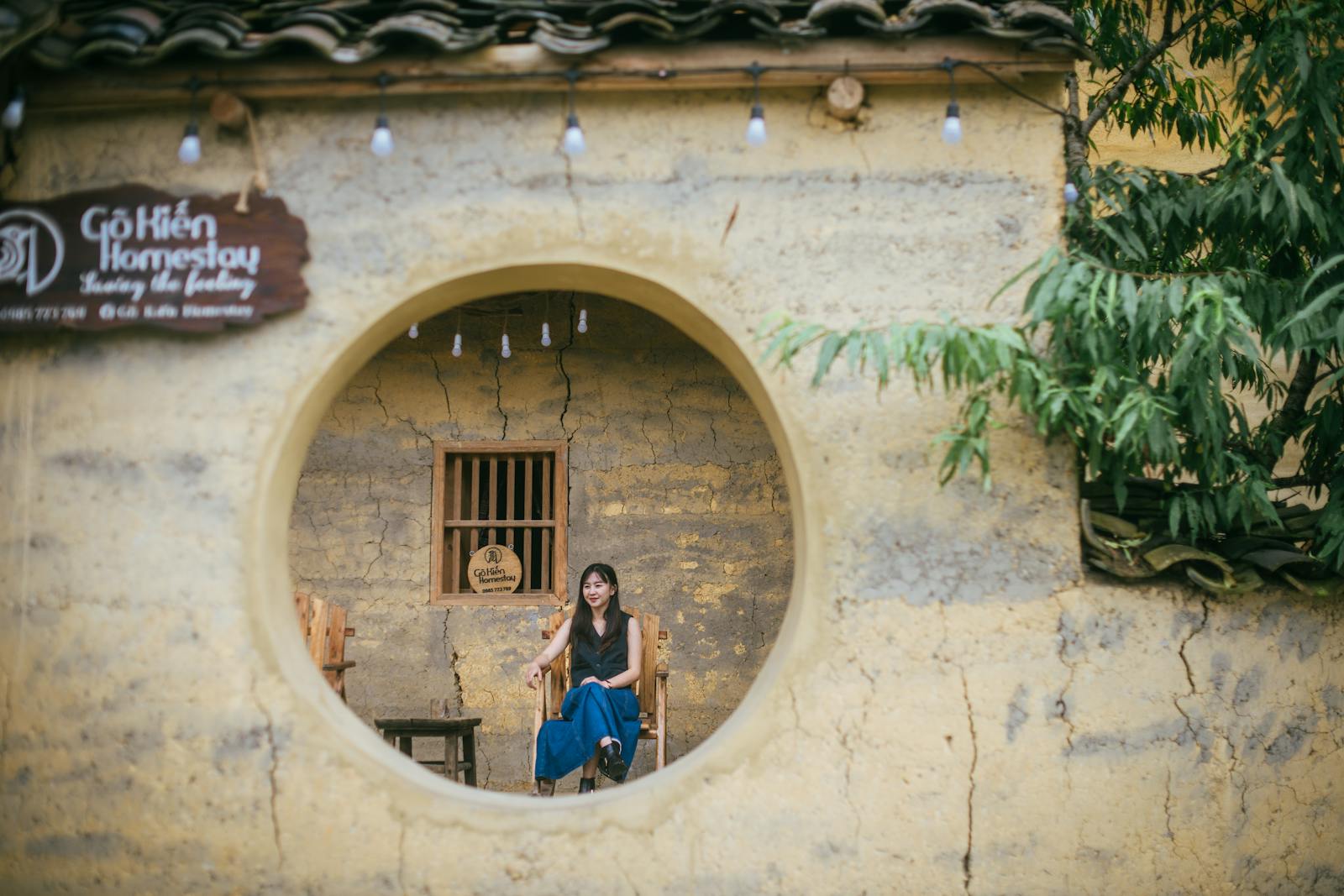 A woman sitting in a round window in a small house